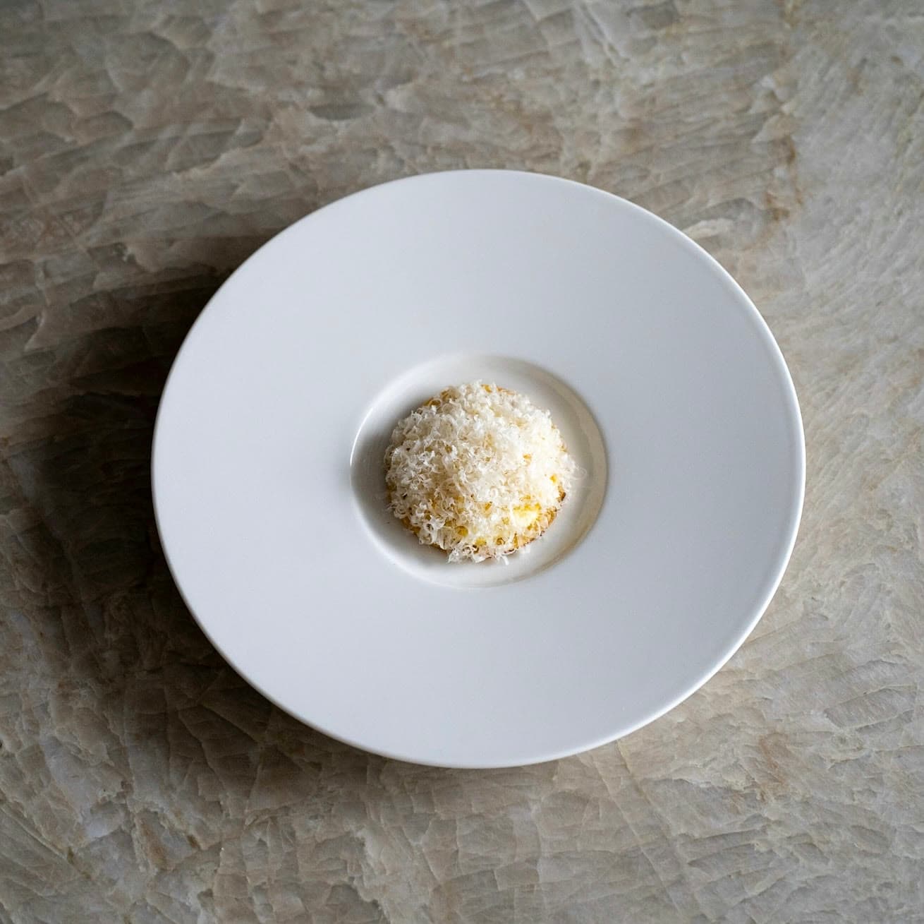A finely grated dome in the centre of a white plate